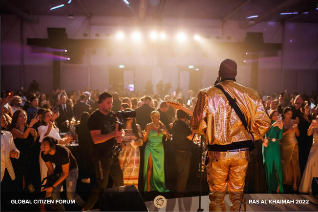 Celebrity charity event to help families in need with singer Adora Aiza in attendance with long emerald green dress and gold head piece.